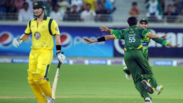 Pakistani cricketer Umar Gul (C) and Umar Akmal celebrate Australian batsman Shane Watson (L) dismissal during the first Twenty20  international cricket match between Pakistan and Australia at the Dubai international cricket stadium on September 5, 2012. Pakistan beat Australia by seven wickets on the back of a superb performance by their spinners.      AFP PHOTO / AAMIR QURESHI