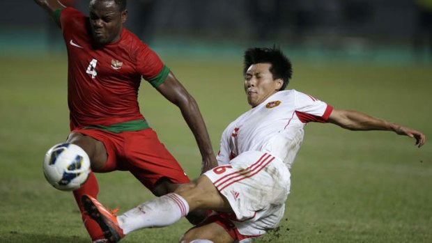 China's Jiang Ning, right, fights for the ball with Indonesia's Victor Igbonefo during their AFC Asian Cup 2015 qualifier.