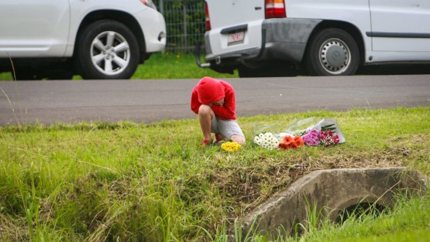 Friends laying flowers in memory of Ryan Teasdale at the site of his accident in Unanderra. 