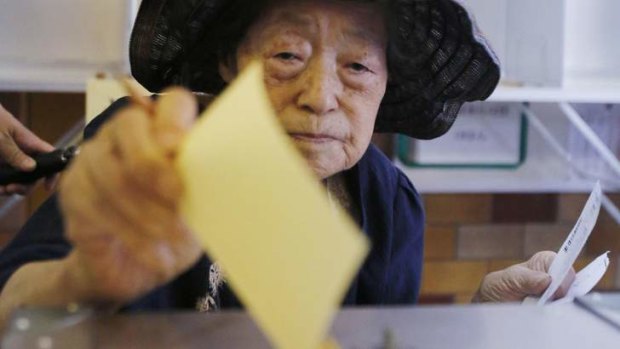 A woman casts her ballot at a polling station during the upper house election in Tokyo.