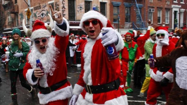 People dressed as Santa Claus walk on the street during SantaCon in New York.