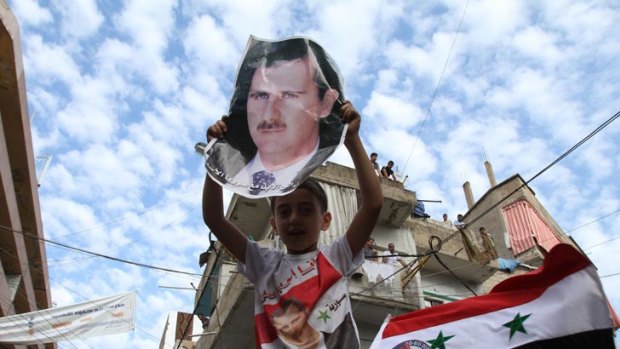 A child carries the image of President Bashar al-Assad.