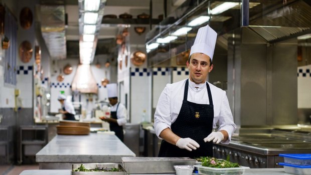 A chef works in the kitchen at Peck deli shop. 
