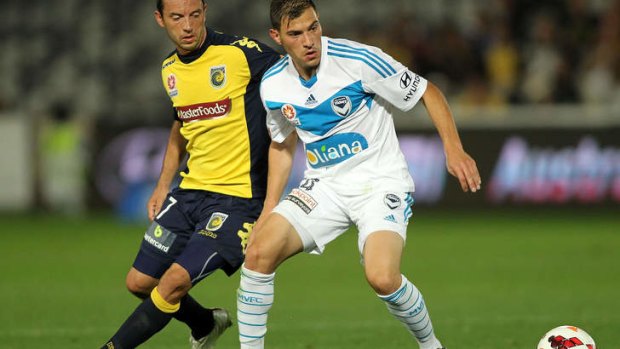 John Hutchinson of the Mariners contests the ball with James Troisi of the Victory.