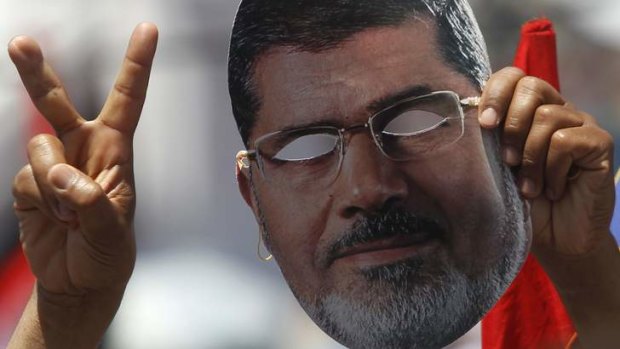 Unmasked: A supporter of ousted Egyptian president Mohamed Mursi holds up a mask at a rally in Cairo.