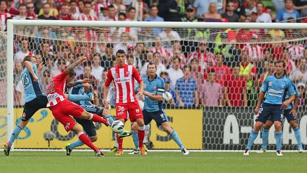Neilly there: Melbourne's Nick Kalmar shoots to score the Heart's first goal as Sydney FC's Lucas Neill (right) watches on.