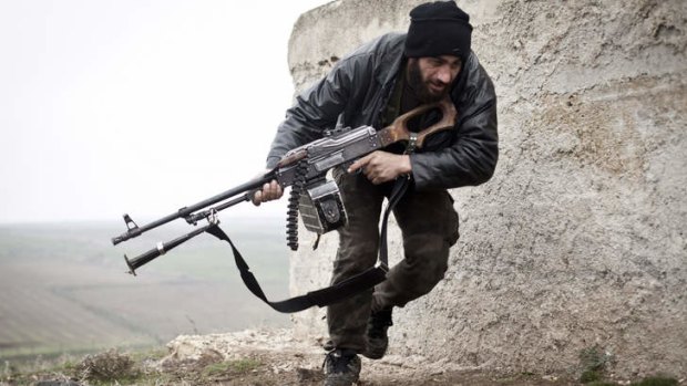 Bitter standoff: A Free Syrian Army fighter takes cover during fighting with the Syrian Army in Azaz last year.