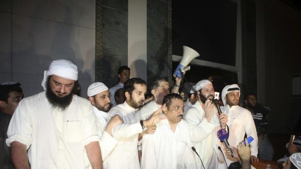 Kuwaiti opposition MPs stand at the podium of the main chamber after storming the parliament.