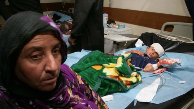 An Iraqi mother sits next to her injured son at a hospital in Dahuk, northwest of Baghdad, Iraq. Tens of people were killed and scores injured in deadly suicide bomb attacks.