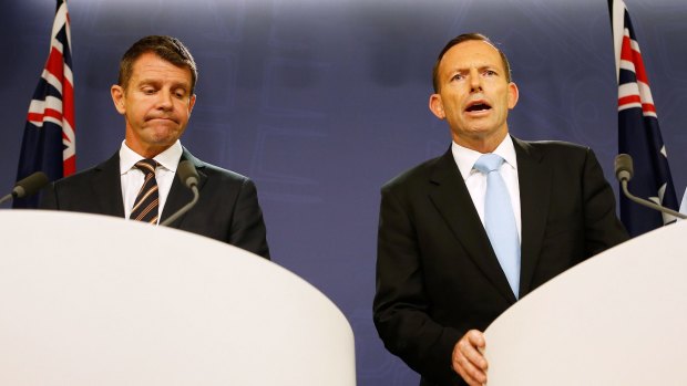 The re-election chances of the government of NSW Premier Mike Baird, left, are being eroded by the unpopularity of Prime Minister Tony Abbott.