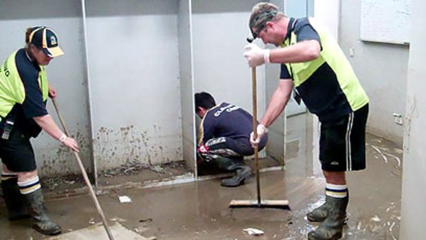 Workers clean out the Suncorp Stadium changerooms.