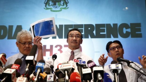 Malaysian acting Transport Minister Hishamuddin Hussein, centre, hold up maps of rescue corridors during a press conference in Kuala Lumpur.