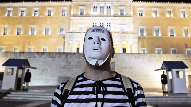 A man dressed as a prisoner protests against the Greek government's austerity measures outside the Greek parliament in Athens.