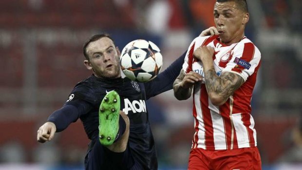 Wayne Rooney fights for the ball with Olympiakos' Jose Holebas.