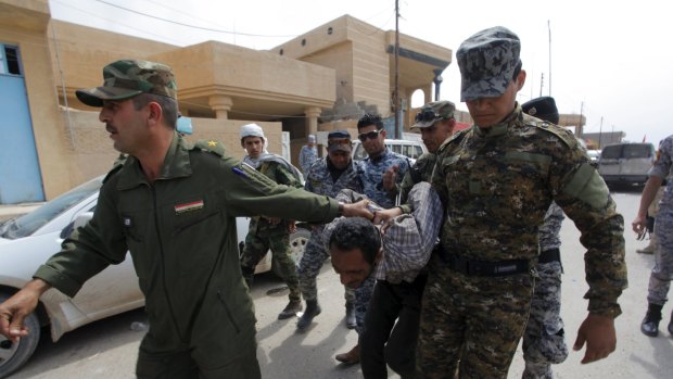 Iraqi security forces arrest a member of the Islamic State in Tikrit on Wednesday. 