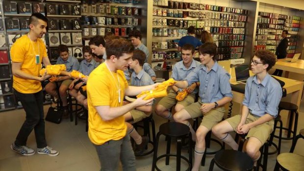 Apple store staff give gifts to Canberra Grammar School students before the students give a Code Cadets presentation at the store in the Canberra Centre.