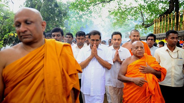 Mr Sirisena, centre, at a Buddhist temple in Kelaniya on Thursday.