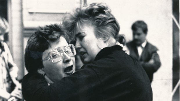 Two Australian Post employees comfort each other in the aftermath of the shooting.