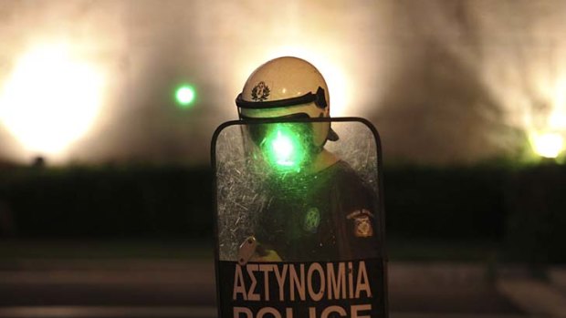 Making their point ... protesters zap a riot policeman with a laser beam in Athens.