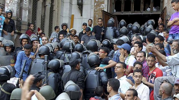 Confrontation: Policemen move into a mosque during clashes with supporters of deposed Egyptian President Mohamed Mursi.