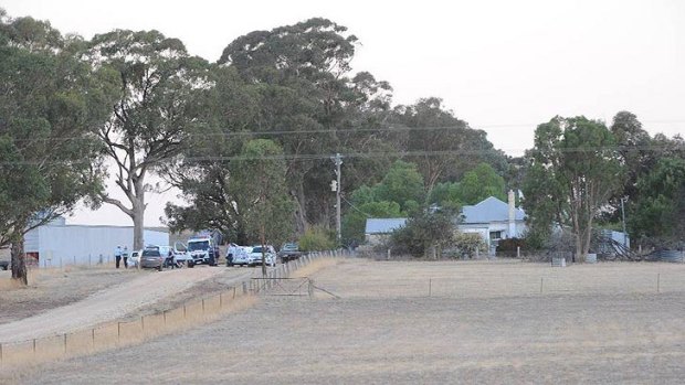 Police near the farmhouse where the bodies were found.