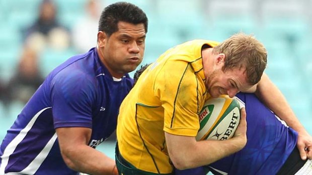 Inside centre Pat McCabe is dumped by the Samoan defence as Australia struggled to break past their opponents.