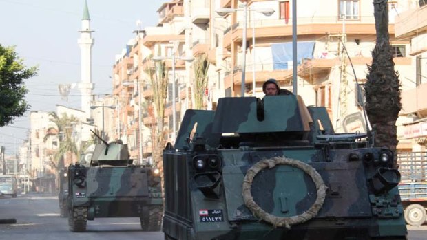 Civil war imminent ... armored vehicles patrol the empty streets of the Sunni Muslim Bab al-Tebbaneh neighbourhood in Tripoli after ten people were killed.