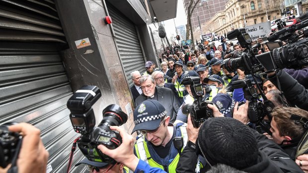Surrounded by the world's media, Cardinal George Pell leaves the Melbourne Magistrates Court on Wedensday.