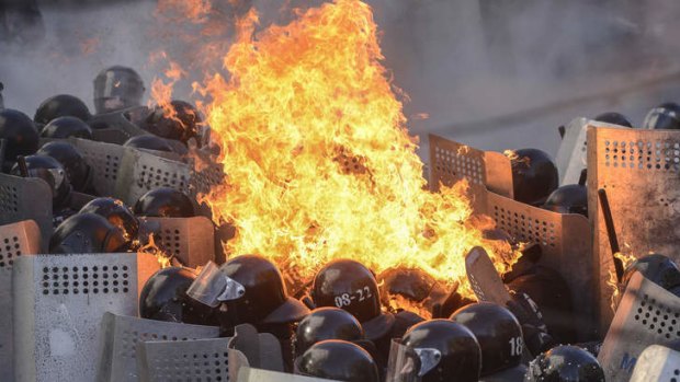 A molotov cocktail hurled by anti-government protesters lands on top of riot police in Kiev.