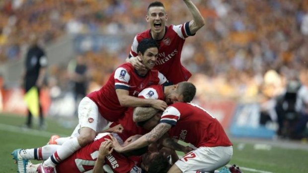 Gunner glory: FA Cup hero Aaron Ramsey is swamped by teammates after scoring the deciding goal in extra time at Wembley Stadium.