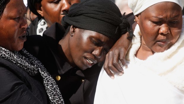 Akon Guode (centre) at the funeral of her three children.