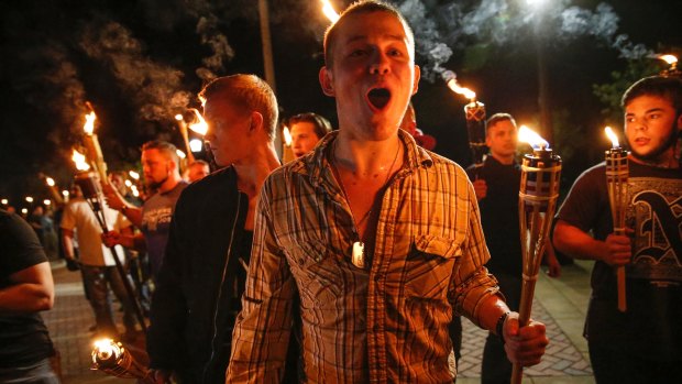 White nationalist groups march with torches through a university campus in Charlottesville.