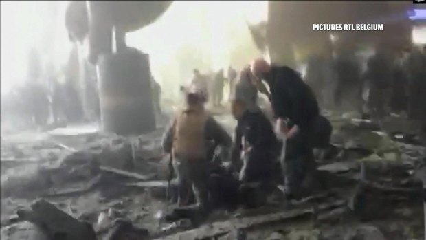 People receive treatment in the debris strewn terminal at Brussels Airport after explosions on Tuesday.