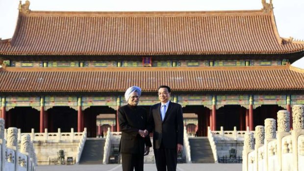 China's Premier Li Keqiang shakes hands with India's Prime Minister Manmohan Singh as they pose for pictures during their visit to the Forbidden City, in Beijing.