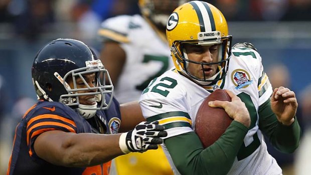 Green Bay Packers' Aaron Rodgers (R) runs from Chicago Bears' Corey Wootton.