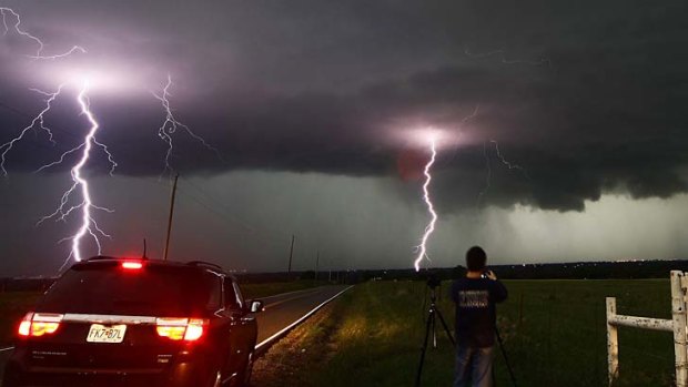 Strike force: Spectators follow tornadic thunderstorms in Cushing, Oklahoma that killed 14 people including a mother and baby.