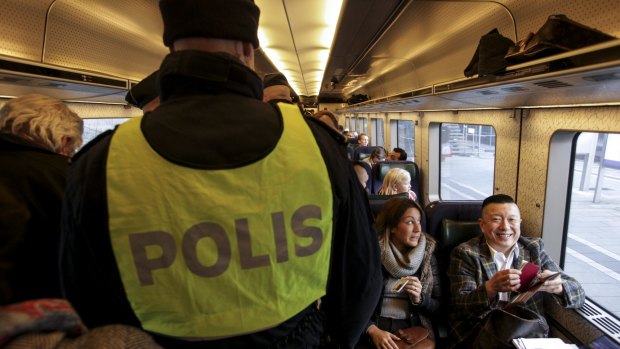 Swedish police check ID papers on a train travelling between Copenhagen in Denmark and Malmo in Sweden.