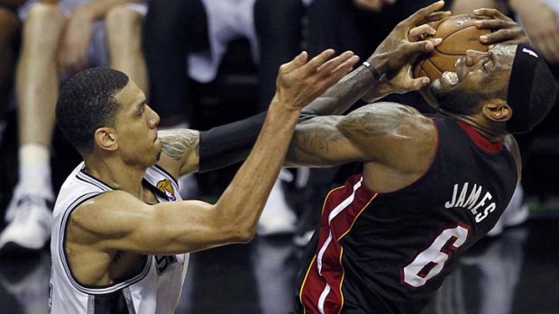 Miami Heat's LeBron James (R) is guarded by San Antonio Spurs' Danny Green, who broke the record for the most successful three shots in a finals series in the second quarter.