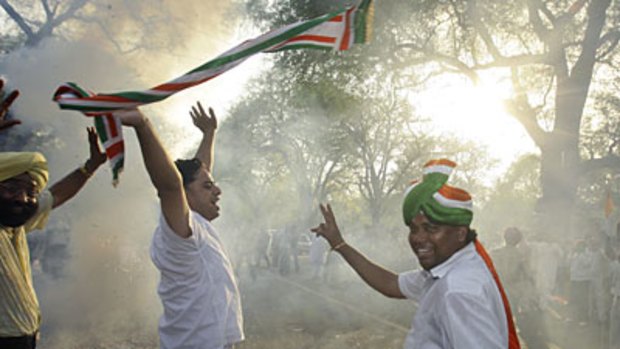 Triumphant... Congress Party supporters celebrate the coalition victory with fireworks outside the party's headquarters in New Delhi.