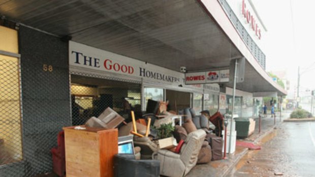 Damaged furniture is piled up on the footpath outside a Toowoomba store yesterday.