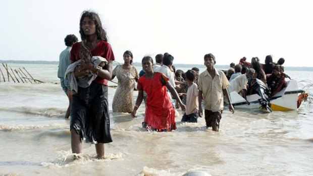 Fears asylum seekers could face torture: Photograph from May 15, 2009 shows Tamil civilians wading and using boats to escape the island's war zone.