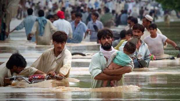 Survivors wade through floodwaters in north-west Pakistan.