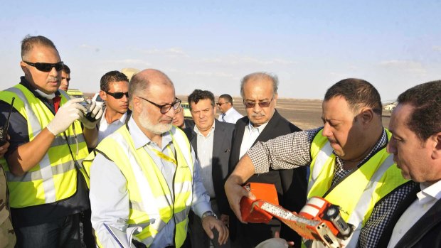 Egyptian Prime Minister Sherif Ismail (third right) looks at the flight data recorder at the site where a Russian plane carrying 224 passengers crashed in Egypt on Saturday. 