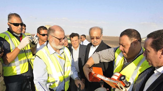 Egyptian Prime Minister Sherif Ismail (third right) looks at the flight data recorder at the site where a Russian plane carrying 224 passengers crashed in Egypt on Saturday. 