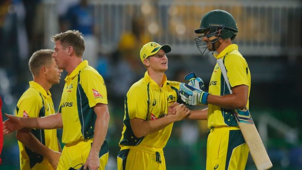Australia's captain Steve Smith, second right, congratulates Mitchell Starc, after defeating Sri Lanka by three wickets during their first one day international cricket match in Sri Lanka.