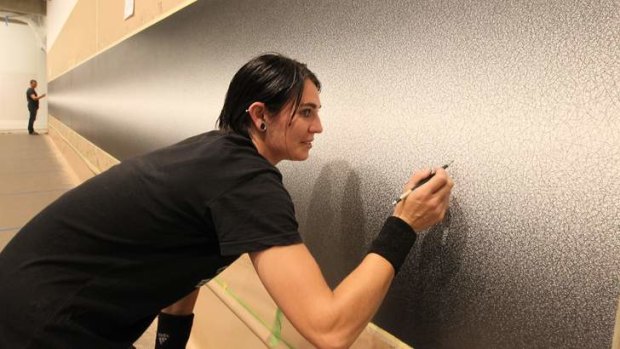 Work in progress: Jemima Flett works on <i>Wall Drawing #1274</i>, a 14 metre long work by Sol LeWitt exhibited at Art Gallery NSW.