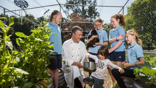 Ainslie Primary students Charlie Robertson (year 1), Indigo Buckman (year 3), Max Piper (pre-school), Holly Bruce (year 4), and Teegen Piper (year 4), with chef Jeff Piper at the school ahead of the release of the Ainslie PS cookbook.  