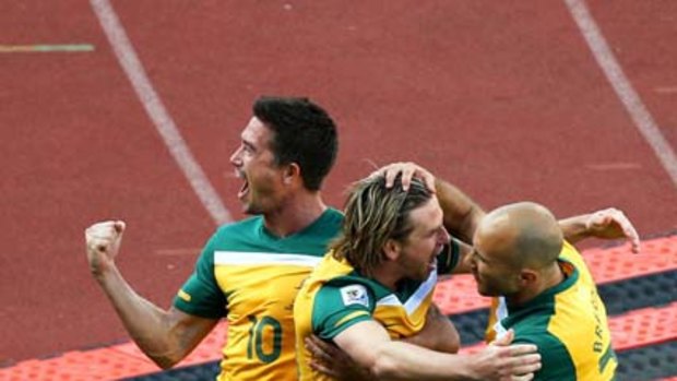Brett Holman celebrates with Harry Kewell (L) and Marco Bresciano (R) after scoring.