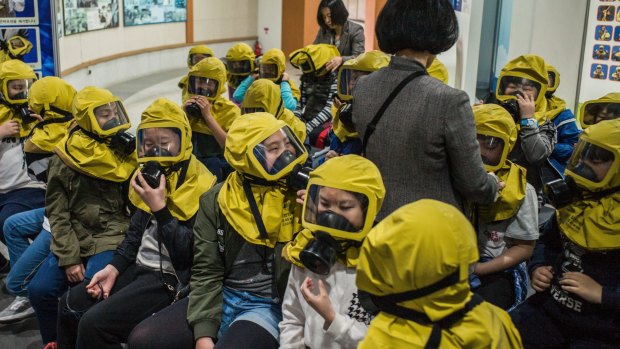 Students learn to use gas masks in case of an event of chemical or biological attacks in Seoul.