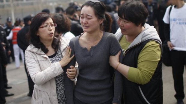 A relative (centre) of passengers on the missing Malaysia Airlines Flight MH370 cries as she participates in a protest outside the Malaysian embassy in Beijing.